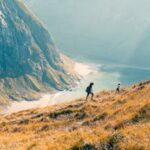 Two hikers explore the stunning landscapes of Fredvang, Norway.